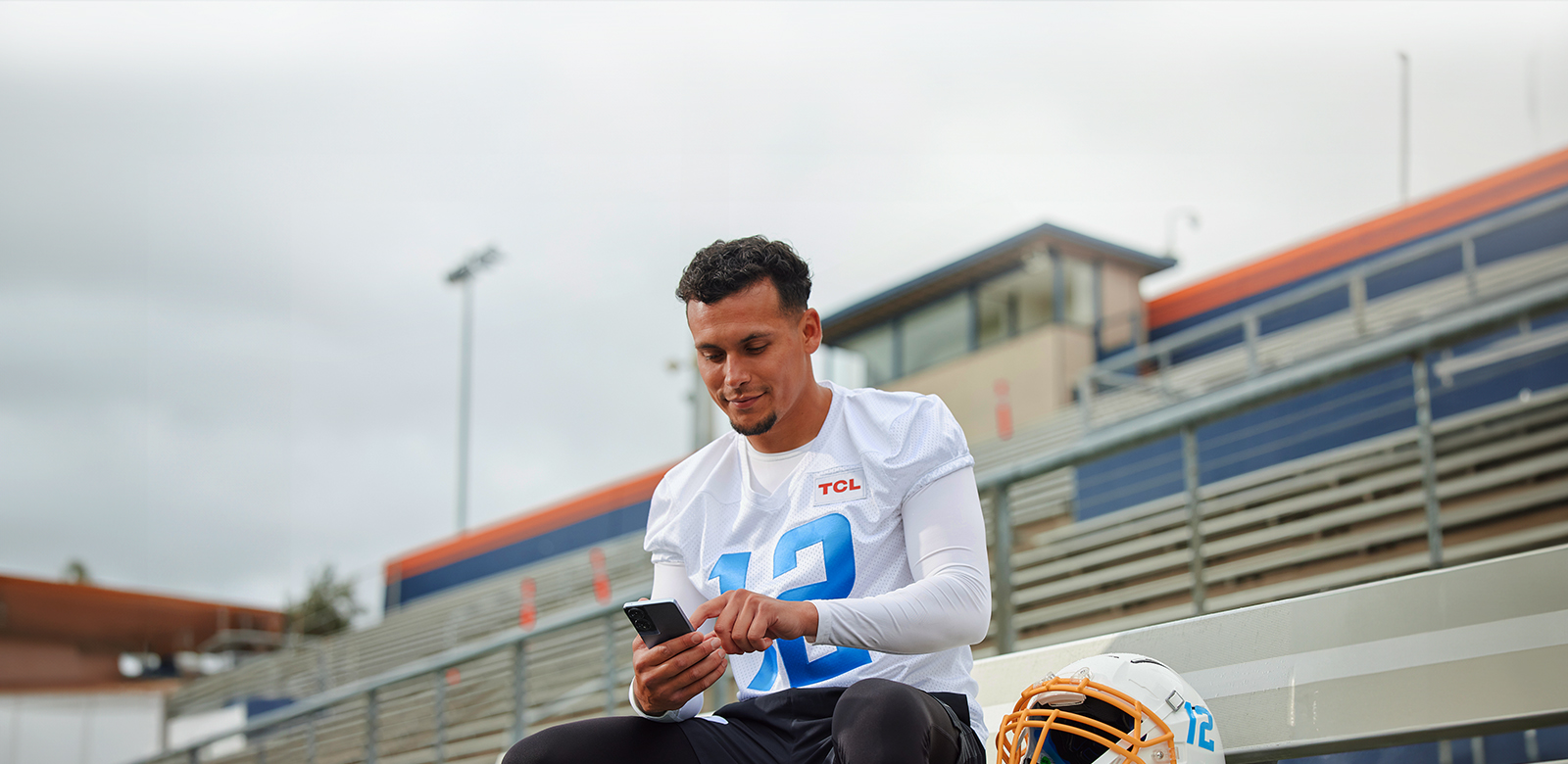 man watching device after football practice